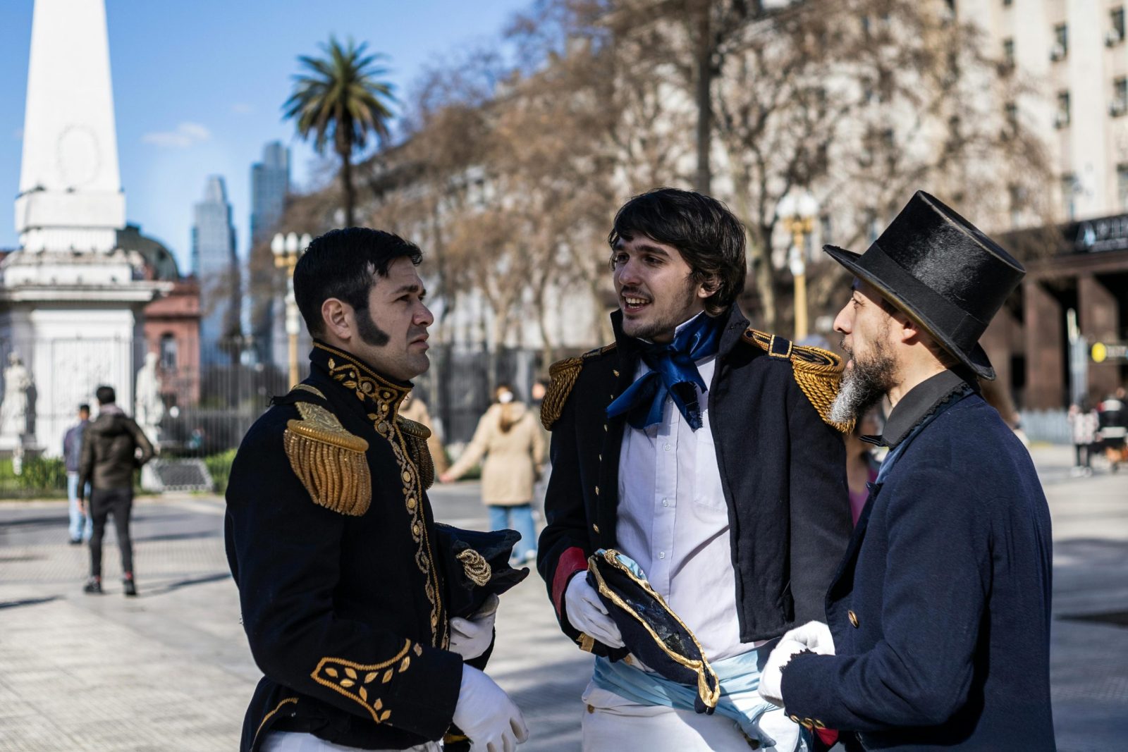 Three men in historical costumes at Plaza de Mayo, Buenos Aires.